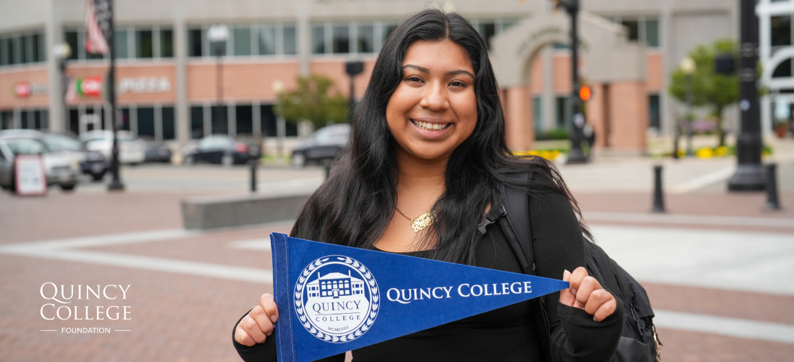 Photo of a female college student holding a blue Quincy College small flag