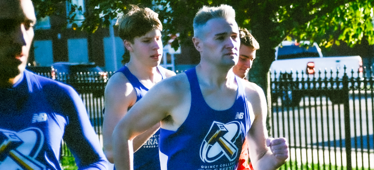 Quincy College Co-ed Cross Country player running outside on a sunny day