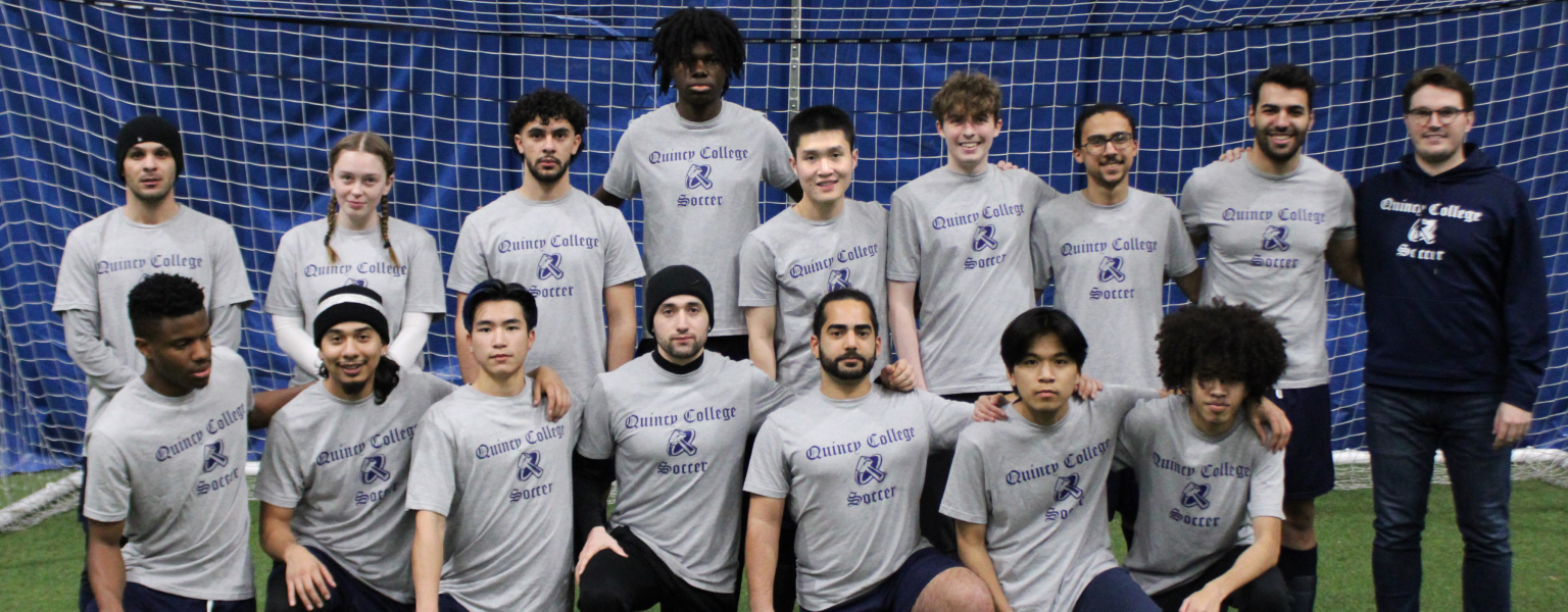 Quincy College Co-ed soccer team posing with their coach on the field